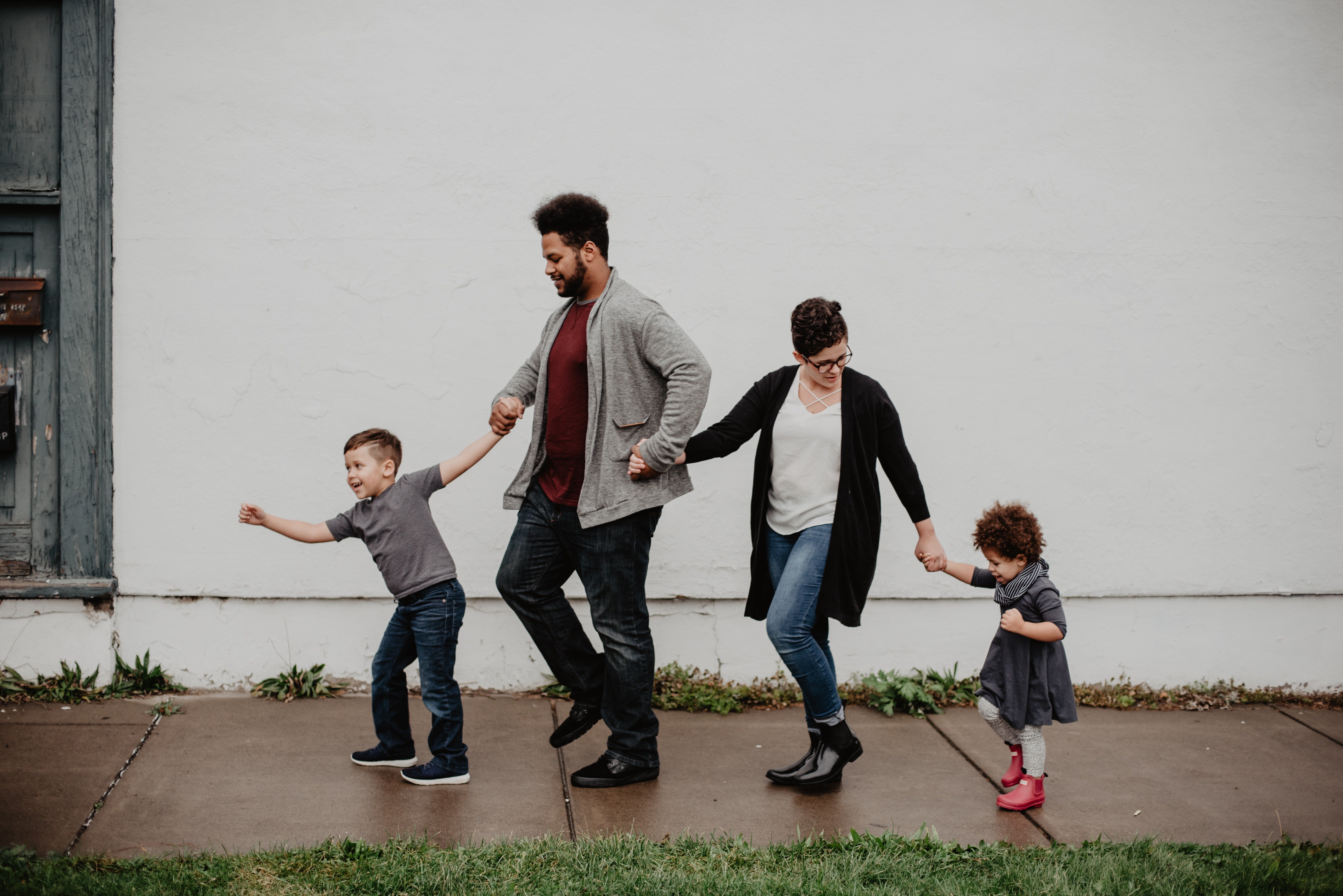 family with two young children in line holding hands