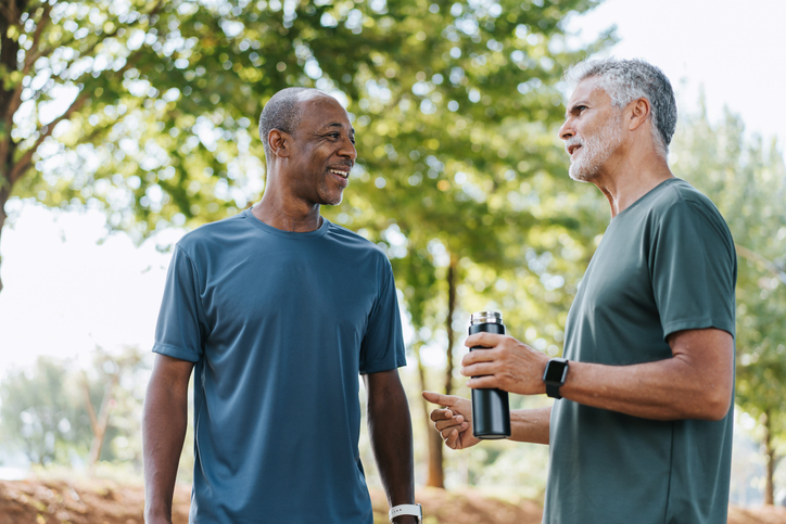 two older men on a run stopping to talk to each other