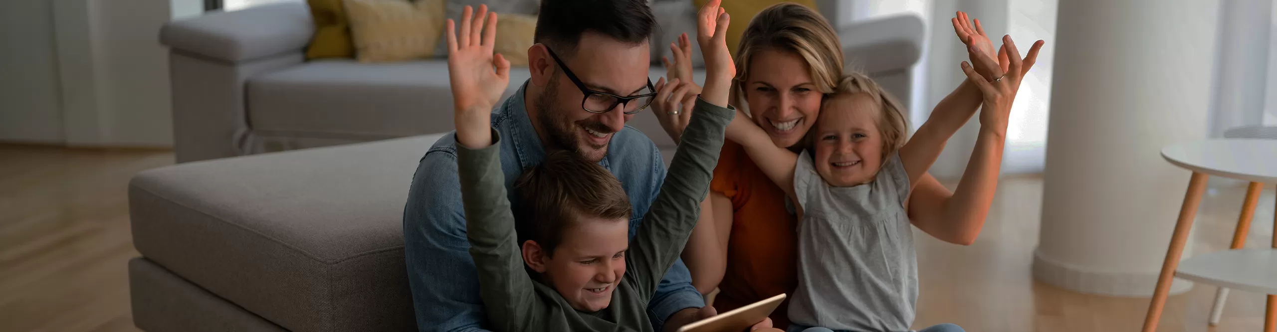 family sitting in the living room with a tablet