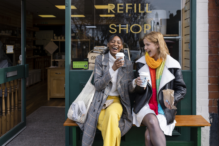 two young women getting coffee and laughing together