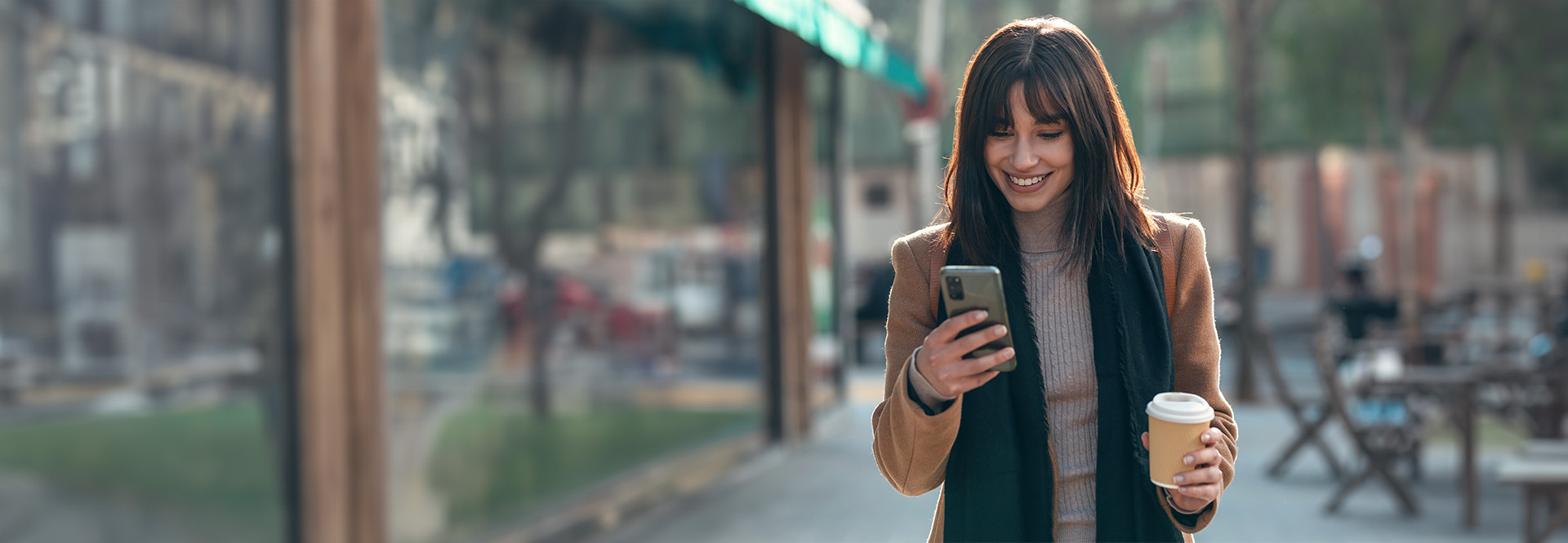 young woman walking looking at her phone