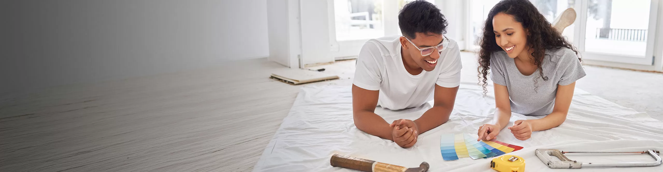 couple laying on ground looking at paint swatches